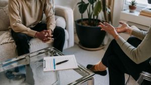 Using Blue Cross Blue Shield for Drug Rehab Coverage & Treatment Options hero image of a person sitting down during a rehab session.