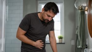 Does Alcohol Cause Kidney Stones hero image of a man with kidney pain.