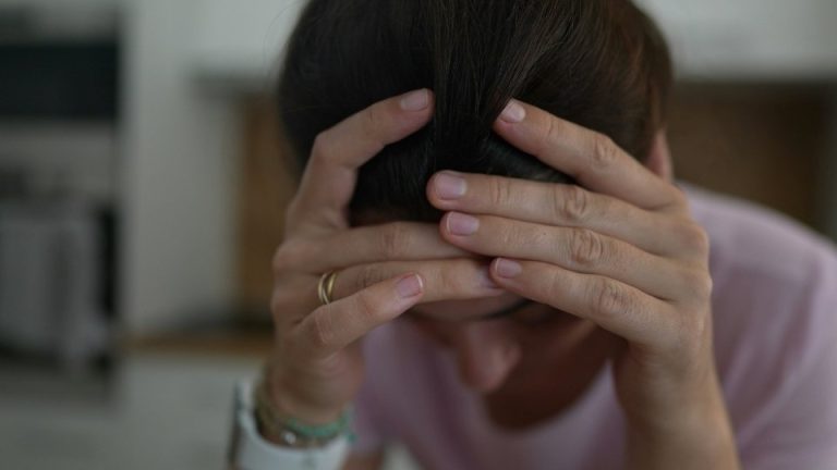 Adderall Withdrawal hero image of a woman looking down struggling with adderall.