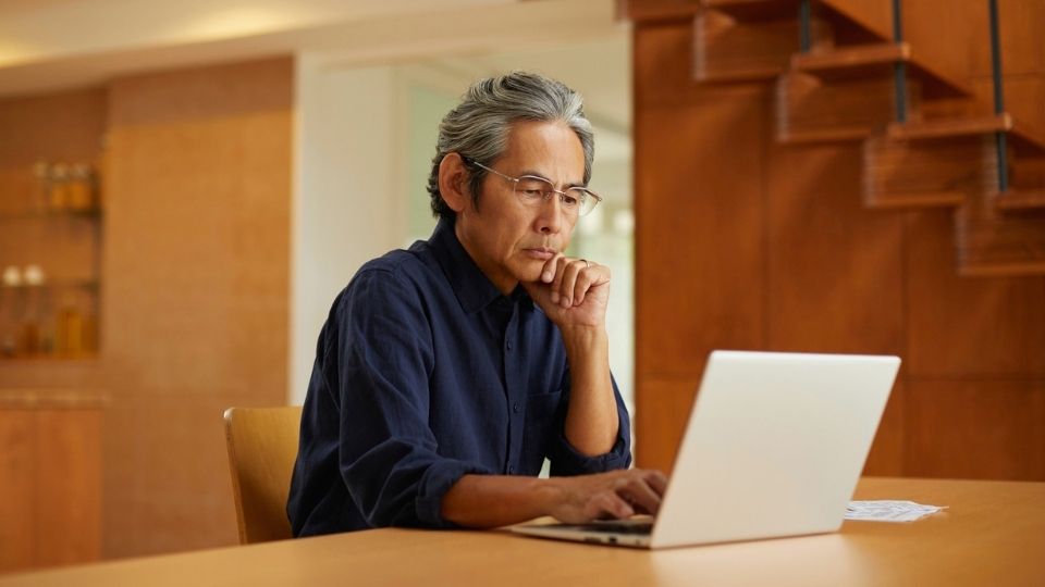 a man looks up cocaine overdose symptoms on his laptop.