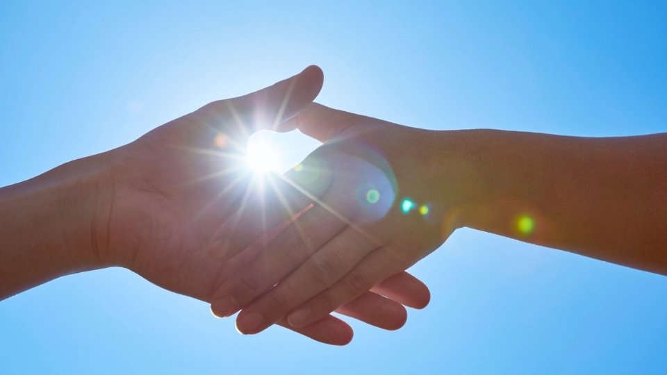 Can You Use Your Health Insurance in Another State hero image a handhshake symobilizing an insurance agreement.