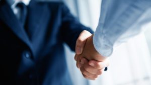 How to Verify Your Insurance for Rehab hero image of a business handshake.