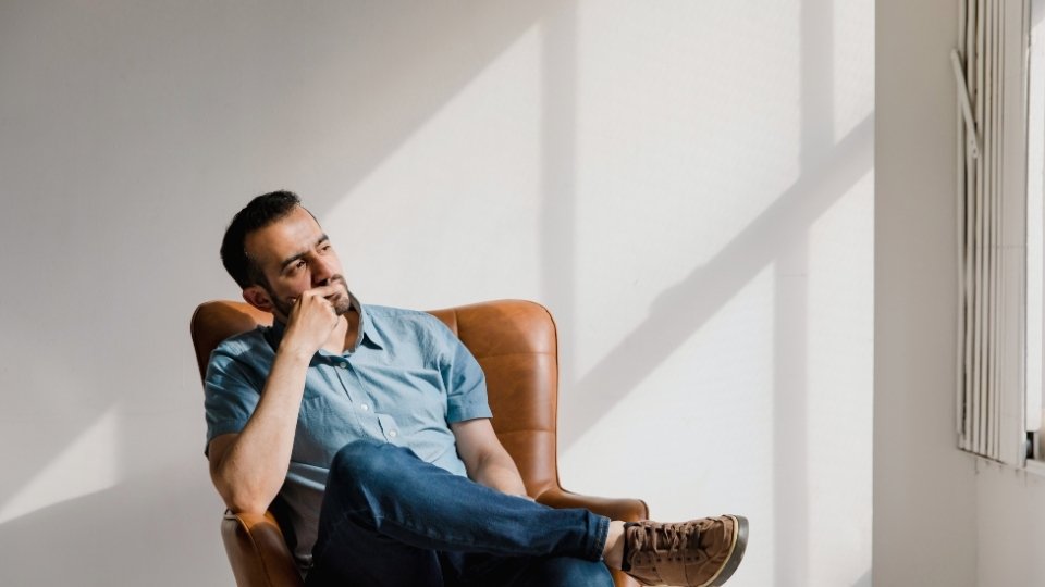 What Is Highmark? hero image of a man thinking about the answer in a chair