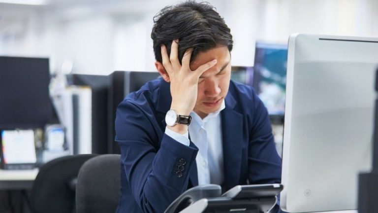 high-functioning alcoholic hero image of a man struggling while at his computer.